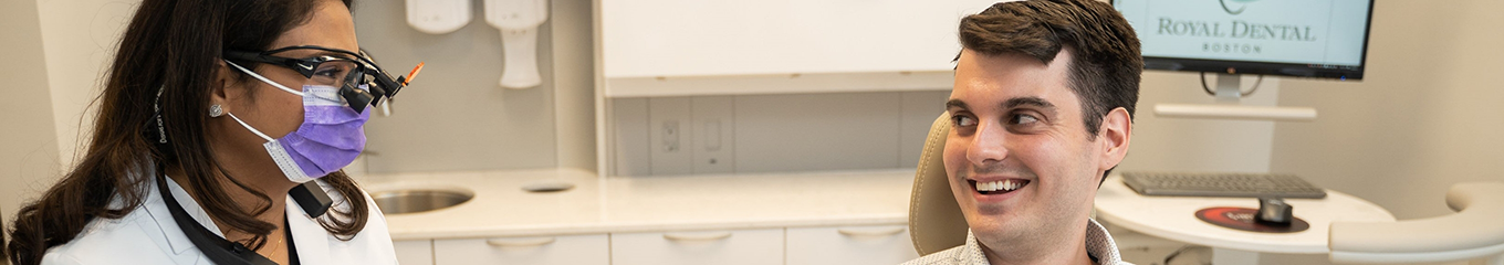 Dentist smiling at a man in the treatment chair