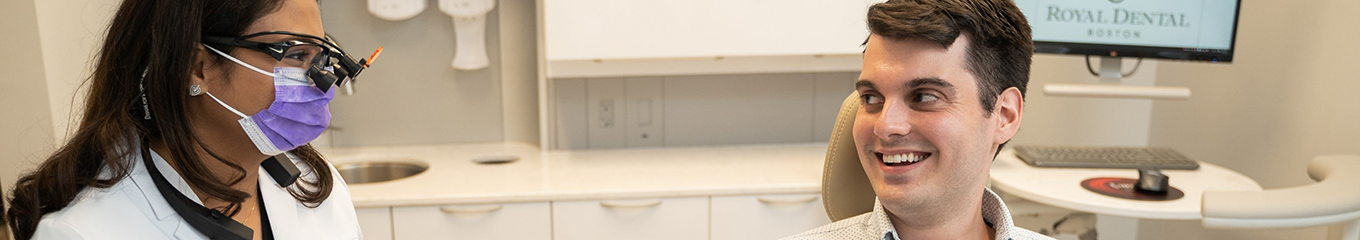 Dentist smiling at a patient in the dental chair