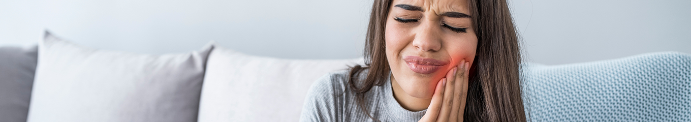 Woman holding her cheek in pain