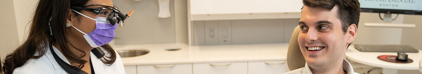 Dentist smiling at a man in the treatment chair